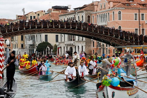 Warga Venesia mengambil bagian dalam parade topeng di Grand Canal selama karnaval Venesia, di Venesia, Italia. Foto: Remo Casilli/REUTERS