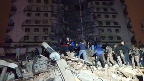 Tim penyelamat bekerja di tengah puing-puing bangunan yang runtuh setelah gempa bumi di Diyarbakir, Turki, Senin (6/2/2023).  Foto: Mahmut BOZARSLAN / AFPTV / AFP