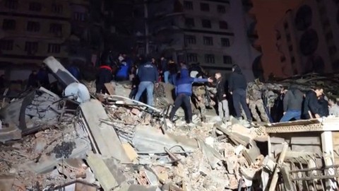 Tim penyelamat bekerja di tengah puing-puing bangunan yang runtuh setelah gempa bumi di Diyarbakir, Turki, Senin (6/2/2023).  Foto: Mahmut BOZARSLAN / AFPTV / AFP