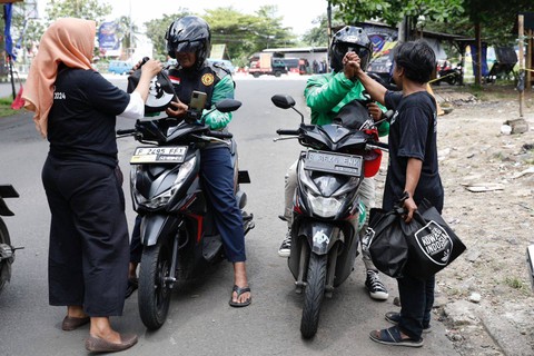 Komunitas Warteg (Kowarteg) Indonesia membagikan makan dan sarung tangan kepada sopir angkot, ojek online (ojol), ojek pangkalan, dan masyarakat umum di Pertigaan Bambu Kuning Cibinong, Kecamatan Bojong Gede, Kabupaten Bogor pada Minggu (5/2) siang. Foto: Dok. Istimewa