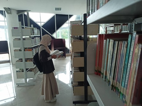 Salah satu pengunjung saat melihat buku di gedung Perpustakaan Modern. | Foto: Galih Prihantoro/ Lampung Geh