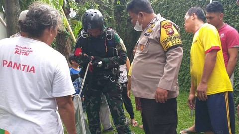 Seorang prajurit TNI nyangkut di rumah warga saat sedang terjun payung akibat angin kencang di Jagakarsa.  Foto: Dok. Istimewa