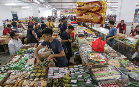 Pedagang melayani pembeli pada Festival Kue Subuh di area parkir gedung Senen Jaya 1 dan 2, Jakarta, Sabtu (11/2/2023) dini hari. Foto: Prabanndaru Wahyuaji/Antara Foto