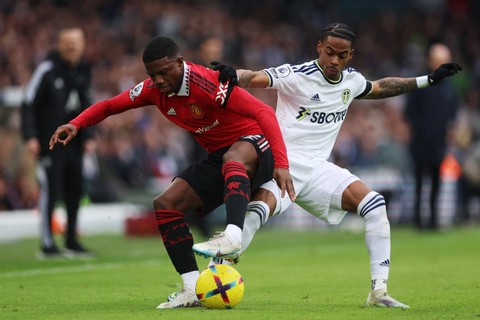 Pemain Manchester United Tyrell Malacia berebut bola dengan pemain Leeds United Crysencio Summerville pada pertandingan lanjutan Liga Inggris di Elland Road, Leeds, Inggris, Minggu (12/3/2023).  Foto: Lee Smith/REUTERS