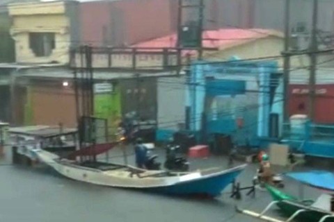 Tangkapan layar video suasana kapal nelayan sudah bersandar di pinggir jalan setelah air permukaan laut naik di Makassar, Sulawesi Selatan, Senin (13/2/2022). Foto: FOTO ANTARA/HO-media sosial