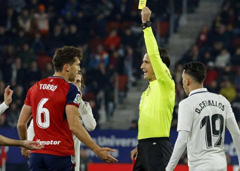 Lucas Torro (kiri) mendapatkan kartu kuning dalam duel Osasuna vs Real Madrid dalam lanjutan Liga Spanyol 2022/23 di Stadion El Sadar, Minggu (19/2) Foto: Vincent West/Reuters