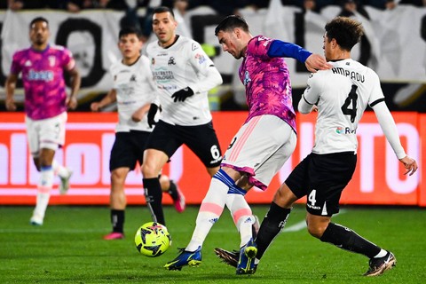 Pemain depan Juventus, Dusan Vlahovic, berduel dengan bek Spezia, Ethan Ampadut, selama pertandingan Liga Italia 2022/23 antara Spezia vs Juventus di Stadion Alberto-Picco, Senin (20/2). Foto: Andreas SOLARO / AFP
