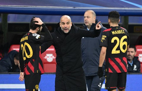 Pelatih Manchester City, Pep Guardiola, berbicara dengan Ilkay Guendogan dan Riyad Mahrez. Foto: Annegret Hilse/REUTERS