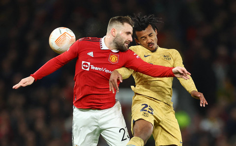 Luke Shaw (kiri) berduel dengan Jules Kounde dalam pertandingan playoff Liga Europa 2022/23 antara Manchester united kontra Barcelona di Stadion Old Trafford, Jumat (24/2). Foto: Carl Recine/Reuters