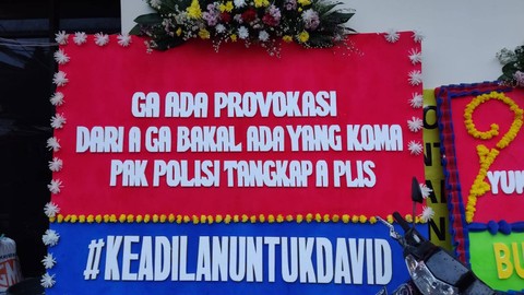 Sejumlah karangan bunga minta polisi tangkap perempuan A di kasus penganiayaan David terpasang di depan Mapolres Jaksel, Sabtu (25/2/2023). Foto: Jonathan Devin/kumparan