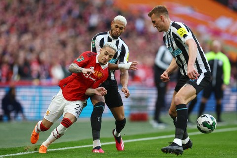 Pemain Manchester United Antony berusaha melewati pemain Newcastle UnitedJoelinton dan Dan Burn pada pertandingan final Piala Liga Inggris di Stadion Wembley, London, Inggris, Minggu (26/2/2023). Foto: Hannah McKay/REUTERS