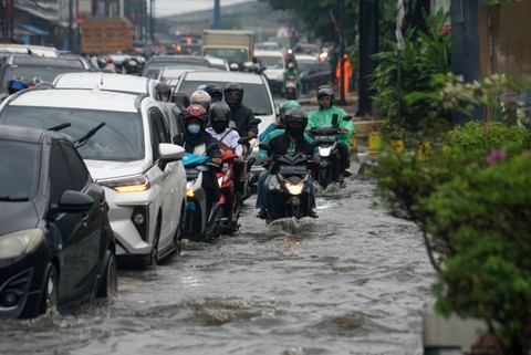 Sejumlah kendaraan melintas di jalanan tergenang banjir karena hujan deras, di kawasan kota Bekasi, Senin (27/2/2023). Foto: Iqbal Firdaus/kumparan