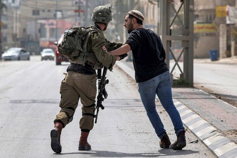 Tentara Israel melakukan penjagaan di sepanjang jalan di kota Huwara dekat Nablus di Tepi Barat, Senin (27/2/2023). Foto: Ronaldo Schemidt/AFP