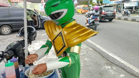 Seorang penjual cilok bernama Juwanso (40) di Kabupaten Sleman mengenakan kostum Power Rangers hijau saat berdagang, Sabtu (4/3). Foto: Arfiansyah Panji Purnandaru/kumparan