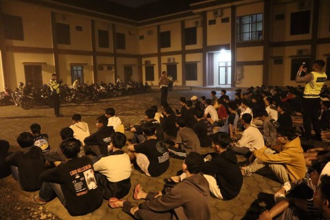 Ratusan pemuda dan barang bukti sepeda motor yang diamankan dalam penggrebekan arena balap liar di Pringsewu, Lampung. | Foto : Dok. Polres Pringsewu.