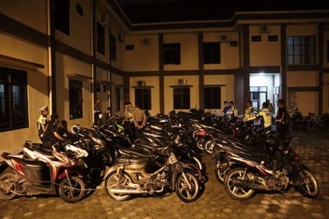 Ratusan pemuda dan barang bukti sepeda motor yang diamankan dalam penggrebekan arena balap liar di Pringsewu, Lampung. | Foto : Dok. Polres Pringsewu.