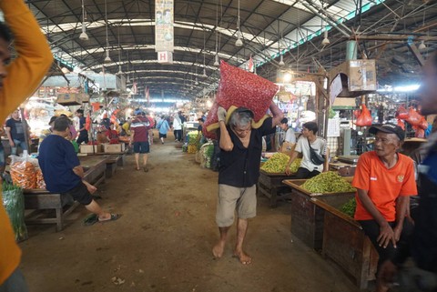 Pekerja mengangkut bawang merah di Pasar Induk Kramat Jati, Jakarta, Senin (6/3/2023). Foto: Iqbal Firdaus/kumparan