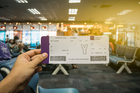 Ilustrasi pria memegang boarding pass. Foto: Shutterstock