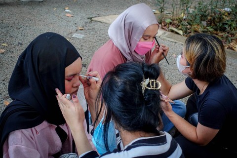 Sejumlah mahasiswa melayani jasa rias kepada pengunjung jelang konser Blackpink yang digelar di Stadion Utama Gelora Bung Karno, Jakarta Pusat, Sabtu (11/3/2023). Foto: Jamal Ramadhan/kumparan