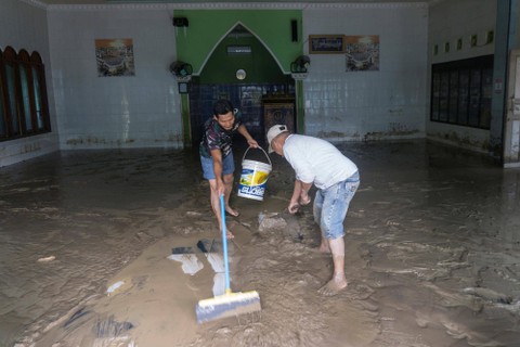 Warga membersihkan material lumpur yang menggenangi masjid akibat banjir bandang di Desa Lubuk Sepang, Kecamatan Pulau Pinang, Kabupaten Lahat, Sumatera Selatan, Sabtu (11/03/2023). Foto: Novian Fazli/Antara Foto