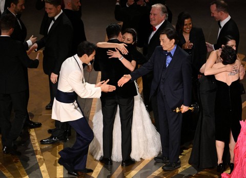 Produser film AS Jonathan Wang merayakan dengan aktris Malaysia Michelle Yeoh setelah memenangkan Oscars untuk "Everything Everywhere All at Once" di Academy Awards Tahunan ke-95 di Dolby Theatre di Hollywood, California, AS, Minggu (12/3/2023). Foto: Patrick T. Fallon/AFP