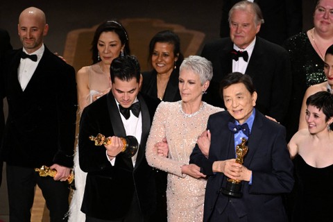 Produser film AS Jonathan Wang (tengah) menerima Oscar untuk Film Terbaik untuk "Everything Everywhere All at Once" di atas panggung Academy Awards Tahunan ke-95 di Dolby Theatre di Hollywood, California, AS, Minggu (12/3/2023). Foto: Patrick T. Fallon/AFP