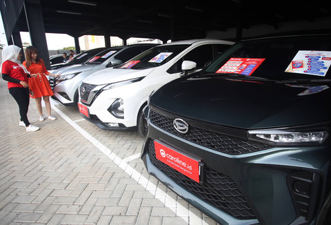 Calon pembeli didampingi tenaga penjual melihat mobil bekas yang dijual di showroom mobil bekas di Gading Serpong, Tangerang, Banten, Jumat (17/3/2023). Foto: ANTARA FOTO/Muhammad Iqbal
