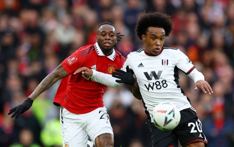 Aaron Wan-Bissaka berduel dengan Wilian saat Manchester United melawan Fulham dalam perempat final Piala FA 2022/23 di Stadion Old Traford, Manchester, Inggris, pada Minggu (19/3) Foto: Carl Recine/Reuters