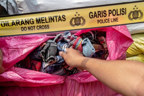 Petugas kepolisian menunjukan barang bukti berupa pakaian bekas hasil pengungkapan kasus penyelundupan barang bekas dan ilegal di Polda Metro Jaya, Jakarta, Jumat (24/3/2023).  Foto: Muhammad Adimaja/ANTARA FOTO