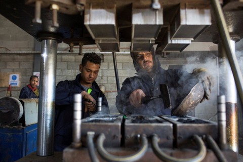Karyawan membuat ubin ramah lingkungan dari berbagai jenis plastik dan limbah di distrik 10 Kota Ramadhan di barat laut Kairo, Mesir. Foto: Hadeer Mahmoud/REUTERS
