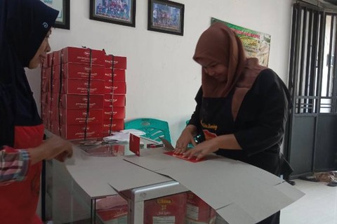 Nur Hayati (kiri) dan karyawan (kanan) sedang menyiapkan pesanan produk Elbina (Dewi Lestari/Kumparan)