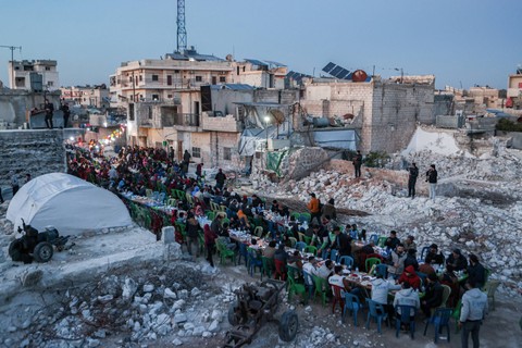 Masyarakat di pedesaan barat provinsi Aleppo yang menjadi koban gempa mengadakan buka puasa bersama pada 31 Maret 2023. Foto: Aaref Watad/AFP