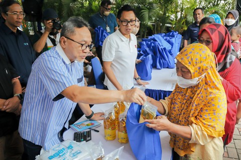 Menteri Perdagangan Zulkifli Hasan melayani warga saat yang membeli minyak saat pelaksanaan pasar murah di Sekolah Kids Republic, di Cipinang Muara, Jakarta Timur, Sabtu (1/4/2023). Foto: Jamal Ramadhan/kumparan