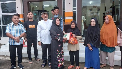 Ketua DWP Sekadau menyerahkan bantuan paket Ramadhan kepada warga. Foto: Dina Mariana/Hi!Pontianak