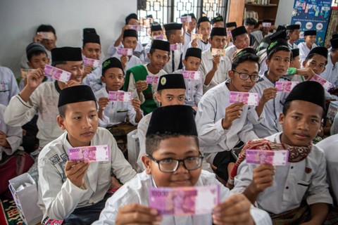 Santri mengamati uang pecahan Rp10 ribu saat peluncuran Program Gerakan Santri Cinta Rupiah Se-Sumatera Selatan di Pesantren Aulia Cendekia Palembang, Sumatera Selatan, Sabtu (1/4/2023). Foto: Nova Wahyudi/ANTARA FOTO