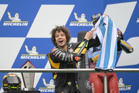Marco Bezzecchi pamer jersi Argentina bertanda tangan Lionel Messi di podium MotoGP Argentina 2023 di Autodromo Termas de Rio Hondo pada 3 April 2023. Foto: JUAN MABROMATA / AFP