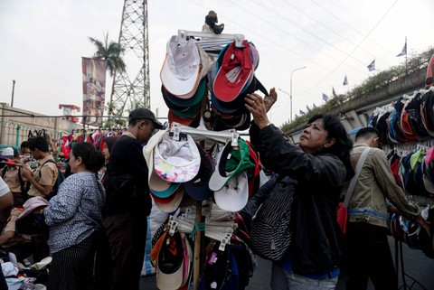 Pasar Senen: Calon pembeli melihat topi bekas di kawasan Pasar Senen, Jakarta, Rabu (6/11/2022). Foto: Iqbal Firdaus/kumparan