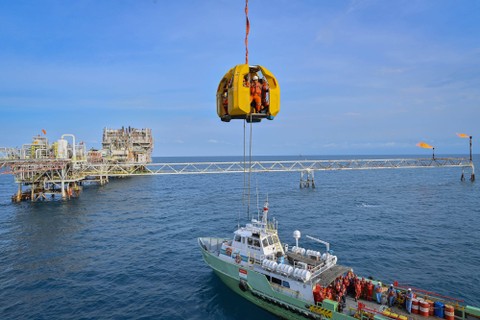 Sejumlah pekerja menaiki 'safety lifting frog' dari kapal ke Anjungan Bravo Flow Station, Pertamina Hulu Energi (PHE) Offshore North West Java (ONWJ), lepas pantai utara Subang, Laut Jawa, Jawa Barat, Minggu (2/4/2023). Foto: Aditya Pradana Putra/Antara Foto