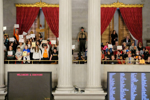 Pengunjuk rasa memegang plakat di dalam Gedung Kongres Tennessee, saat protes terkait insiden penembakan di Covenant School, di Nashville, Tennessee, AS, Senin (3/4/2023). Foto: Kevin Wurm/REUTERS