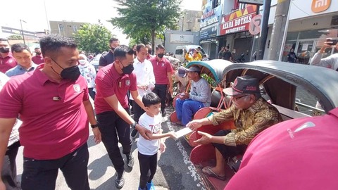 Presiden Jokowi bersama Ibu Iriana Jokowi ajak Jan Ethes membagikan bantuan kepada warga dan pedagang di tiga pasar tradisional di Kota Solo, Jawa Tengah, Minggu (9/4).  Foto: Dok. Istimewa
