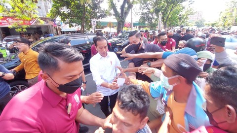 Presiden Jokowi bersama Ibu Iriana Jokowi ajak Jan Ethes membagikan bantuan kepada warga dan pedagang di tiga pasar tradisional di Kota Solo, Jawa Tengah, Minggu (9/4).  Foto: Dok. Istimewa