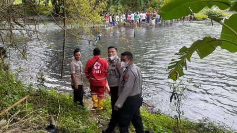 Petugas mengevakuasi mayat bayi yang ditemukan warga di Dam Sungai Bedok Banyon, Sewon, Bantul, Minggu (9/4). Foto: Polres Bantul