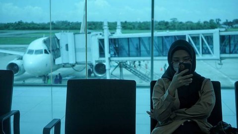 Seorang penupang pesawat di Bandara Sultan Mahmud Badaruddin II yang menunggu jadwal keberangkatan yang terlambat, Foto: abp/Urban Id