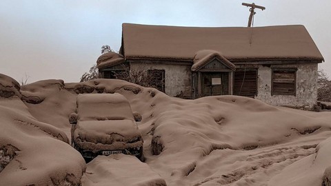 Sebuah rumah dan mobil yang tertutup debu vulkanik setelah letusan gunung berapi Shiveluch di wilayah Kamchatka, Rusia, Rabu (11/4/2023). Foto: Kepala distrik kota Ust-Kamchatsky/Handout via REUTERS