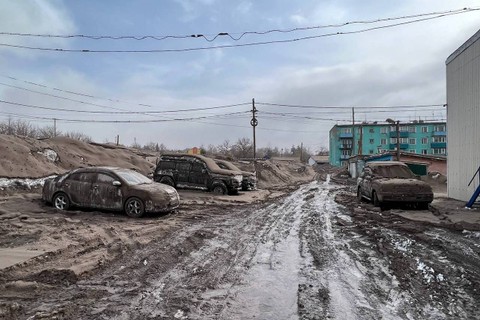 Pemandangan menunjukkan jalan dan kendaraan yang tertutup debu vulkanik setelah letusan gunung berapi Shiveluch di pemukiman Klyuchi di Semenanjung Kamchatka, Rusia, Rabu (11/4/2023). Foto: Kepala distrik kota Ust-Kamchatsky/Handout via REUTERS