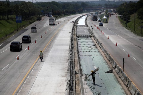 Pekerja memasang pondasi pengecoran jalan pada proyek pelebaran jalan di rest area KM 86, Jawa Barat, Rabu (12/4/2023). Foto: Aditia Noviansyah/kumparan