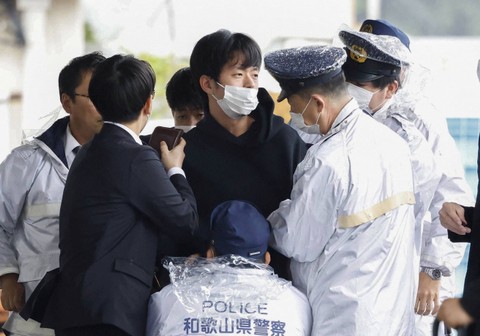 Seorang pria diamankan polisi setelah melemparkan benda mirip pipa ke Perdana Menteri Jepang Fumio Kishida, di Wakayama, Prefektur Wakayama, Jepang barat daya, Sabtu (15/4/2023). Foto: Kyodo via REUTERS 