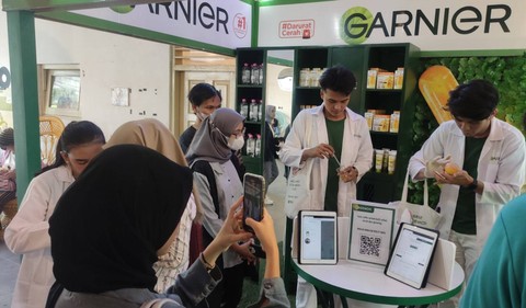 Par pengunjung mencoba produk di di booth #DaruratCerah. Foto: dok. Garnier