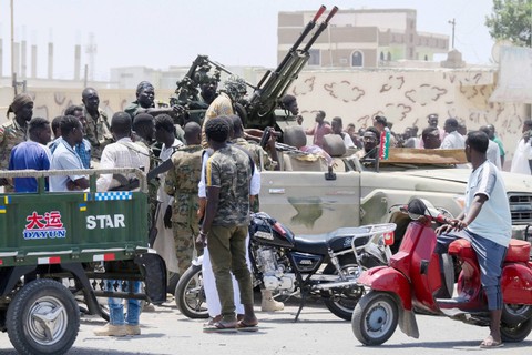 Warga berkumpul dengan tentara yang setia kepada panglima militer Abdel Fattah al-Burhan, di kota Laut Merah Port Sudan pada 16 April 2023. Foto: AFP