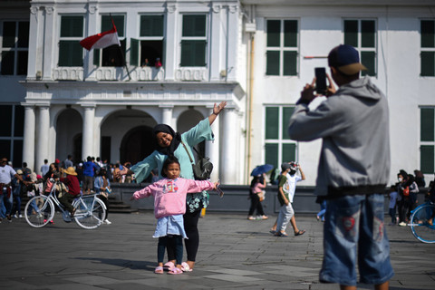 Wisatawan berfoto di Taman Fatahillah, Kota Tua, Jakarta, Senin (24/4/2023). Foto: Aditya Pradana Putra/Antara Foto 